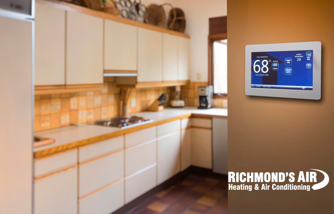 close-up of home thermostat with kitchen in the background